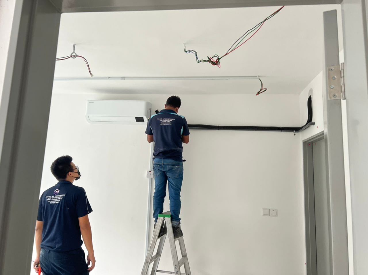 doi bărbați lucrând la un perete într-o cameră, concentrându-se pe renovarea și îmbunătățirea spațiului interior